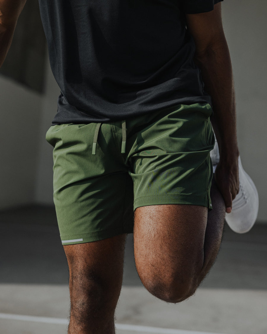 Man wearing Run Short v2 Military Green Tech Tee in Solid Black