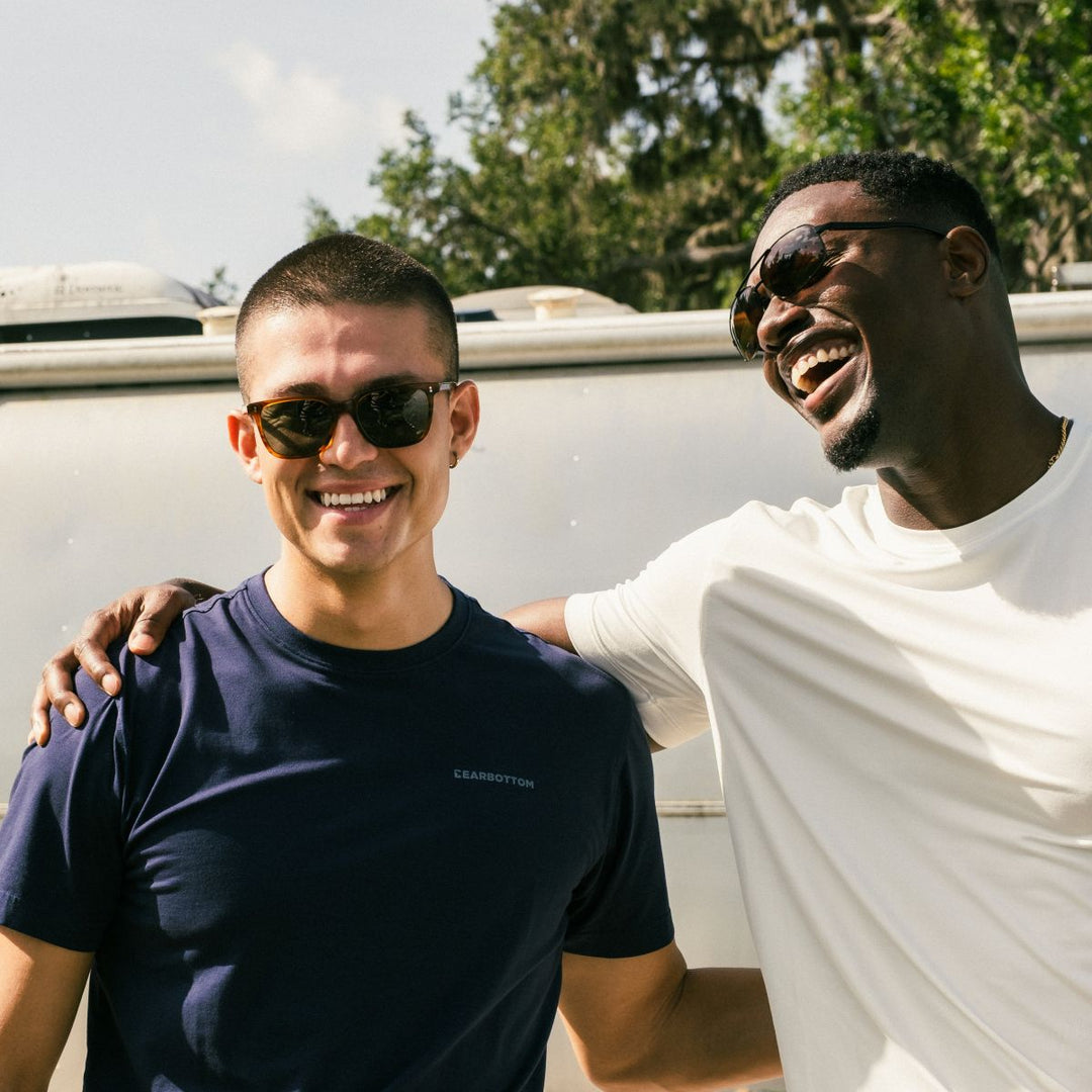 Man wearing Natural Dye Tee in Navy and anther man wearing supima tee in white