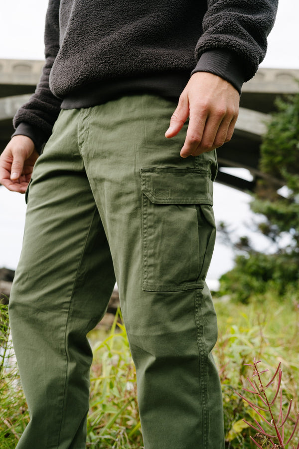 A man outdoors wearing the Stretch Cargo Pants in Military Green