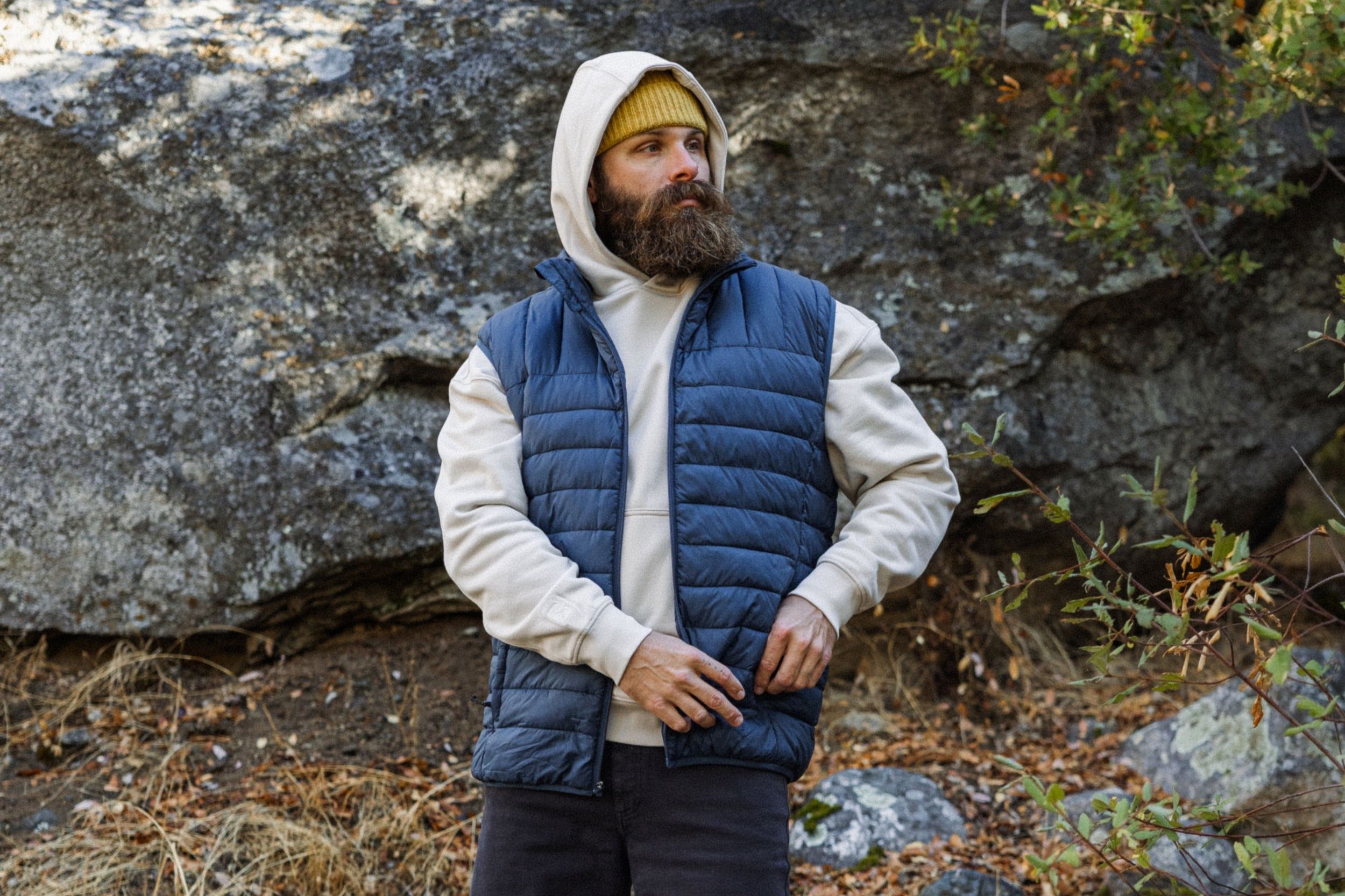 Man hiking wearing Primaloft Packable Vest in Navy and Lounge Hoodie in Bone