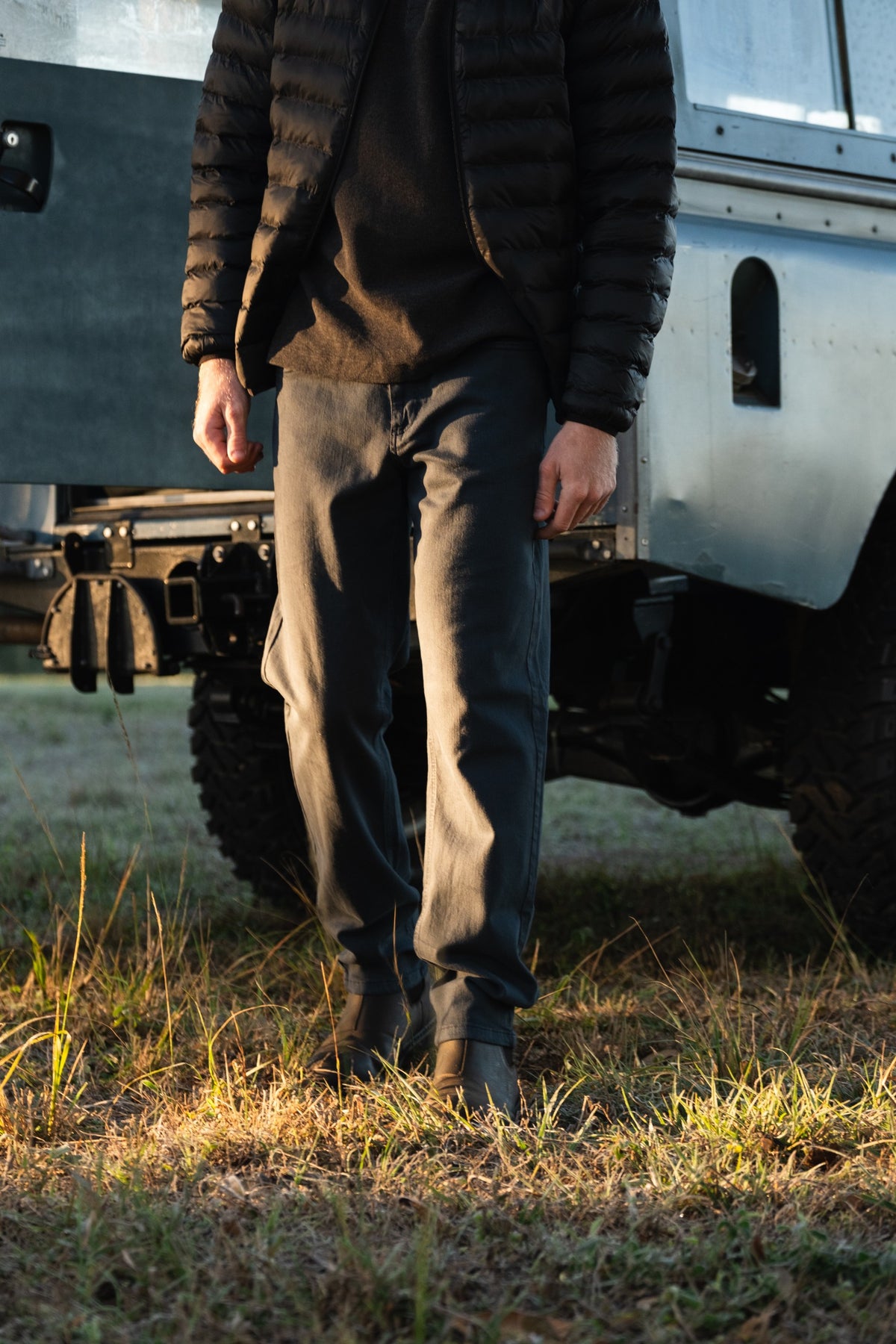 A man in an outdoor setting wearing the Stretch Travel Jeans in Black.