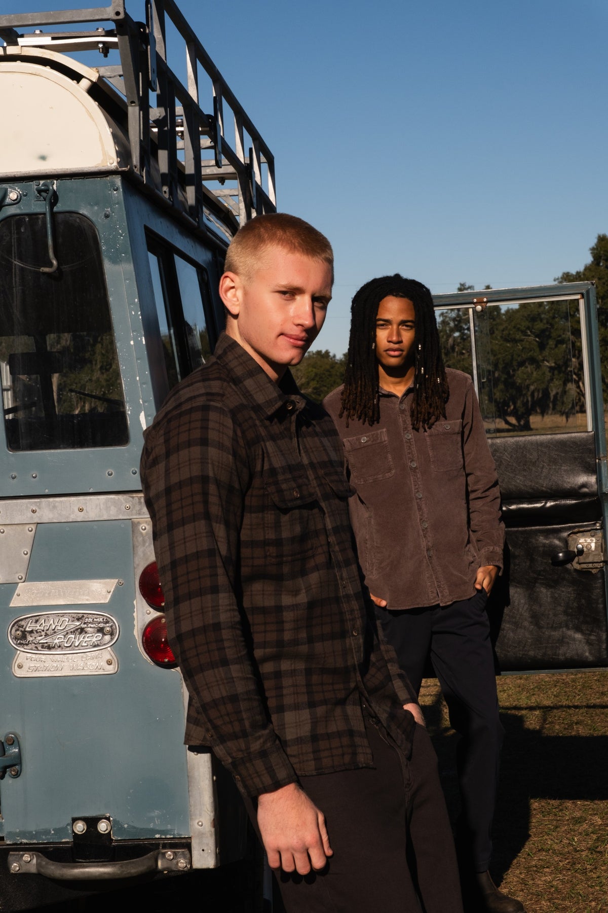 2 men in an outdoor setting wearing our Everyday Flannel Shirt in Moth / Coal and the Corduroy Snap Overshirt in Cocoa.