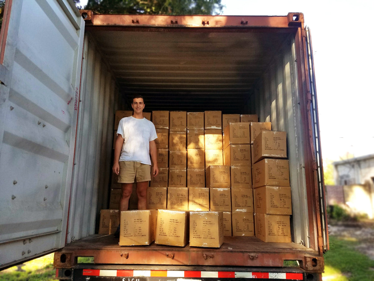 Founder Robert Felder standing inside an open shipping container stacked with cardboard boxes.
