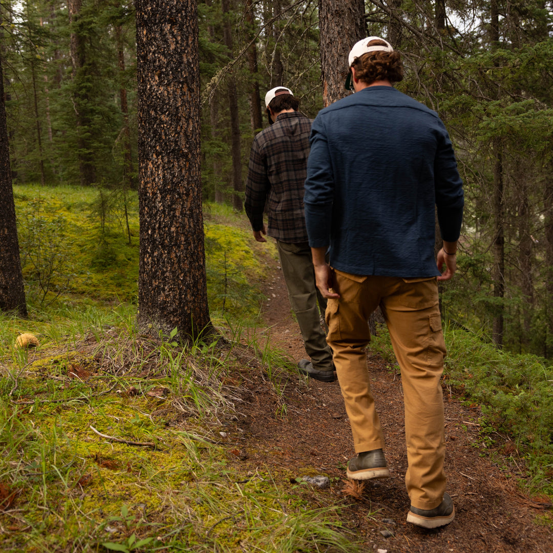Two people walking on a trail through a forest with man wearing Rugby Crew Navy and Stretch Cargo Pant British Khaki