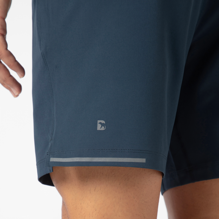 Run Short v2 7" Navy back close up of left leg with reflective B logo and reflective strip on hem on model 