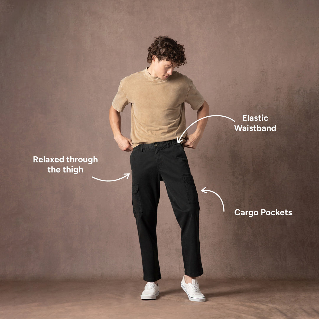A man modeling the Stretch Cargo Pants in Black with text call outs highlighting features.