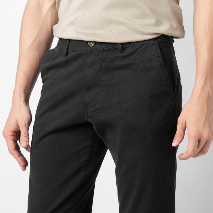 A close up of the black Stretch Jogger showing the premium cotton fabric, button closure, belt loops and slanted side pockets at the waist.