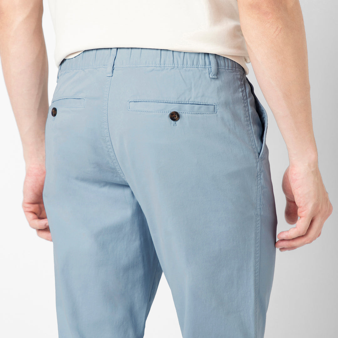 A close up of the back of the Coastal light blue Stretch Jogger, showing the buttoned welt pocket and the elastic waistband.