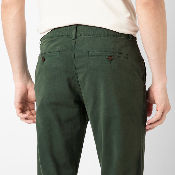 A close up of the back of the Dark Sage Stretch Jogger, showing the buttoned welt pocket and the elastic waistband.