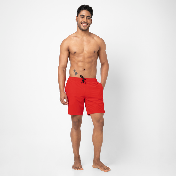 Full body view of a model wearing the Stretch Swim Trunk (Clearance) in solid Red, 7" inseam.