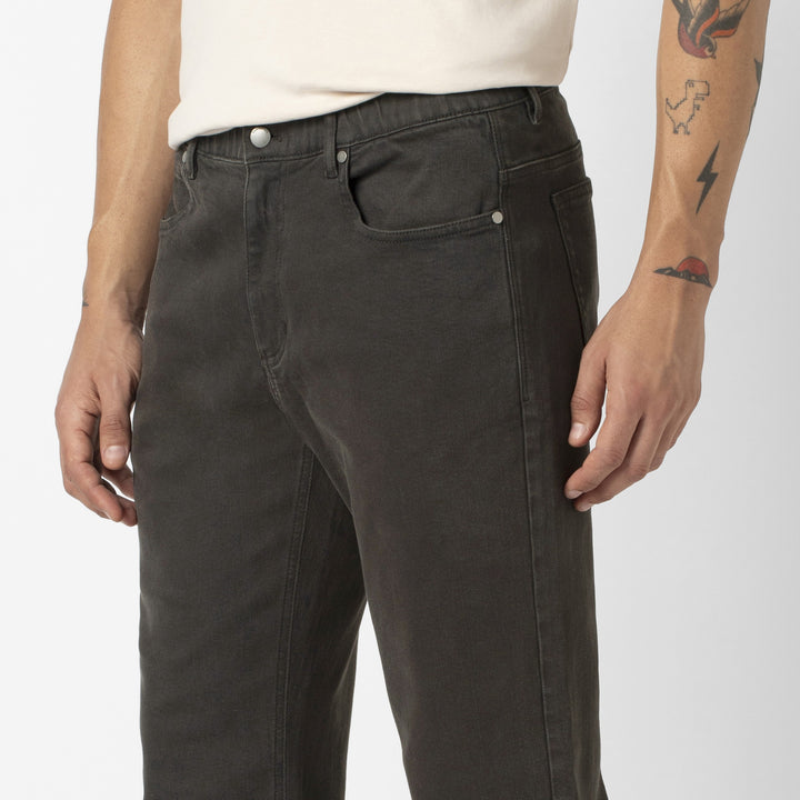 A close up photo of a model wearing the Stretch Travel Jean in Charcoal Black.