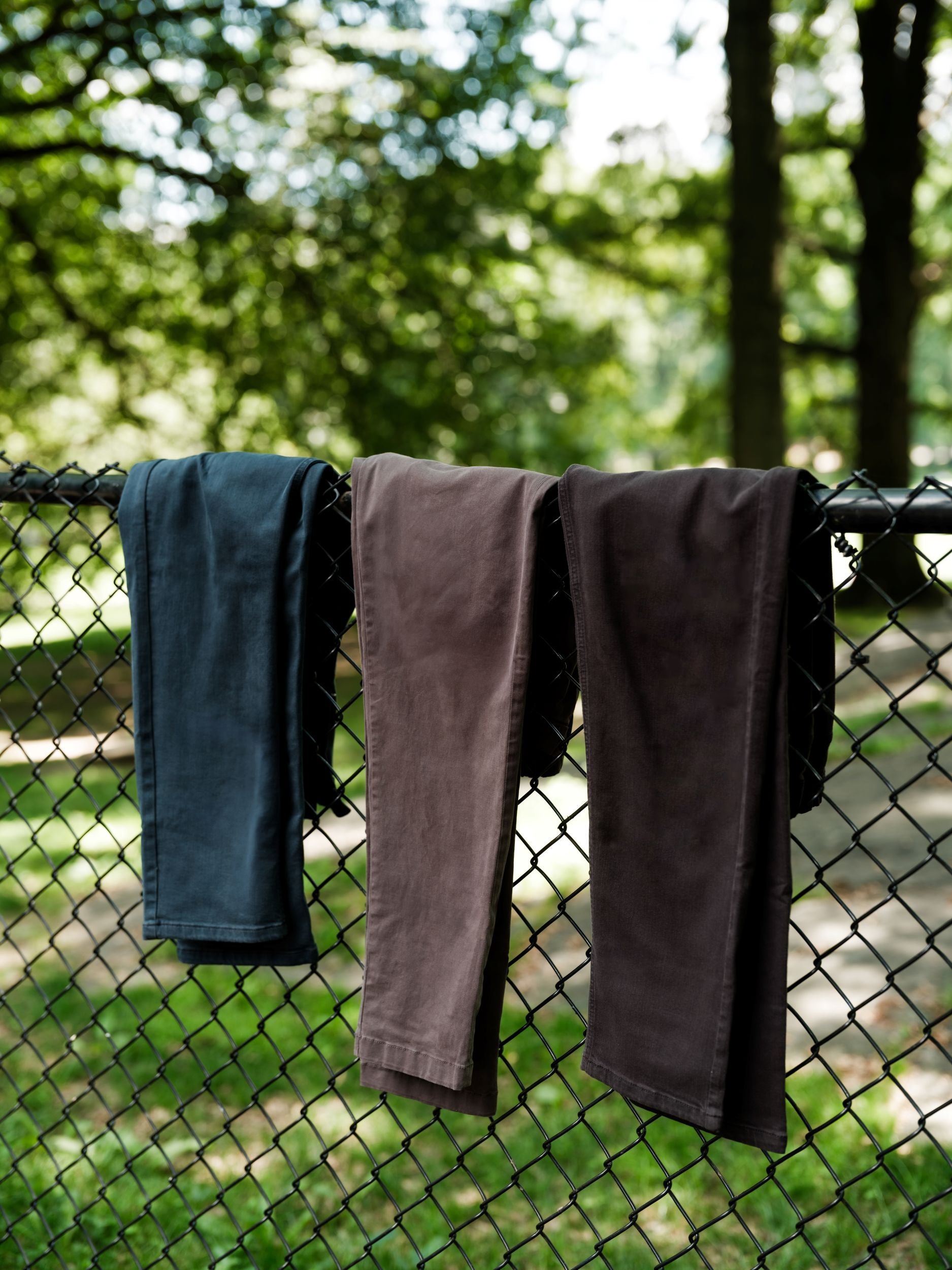Assortment of Stretch Chino Pants hanging on fence.