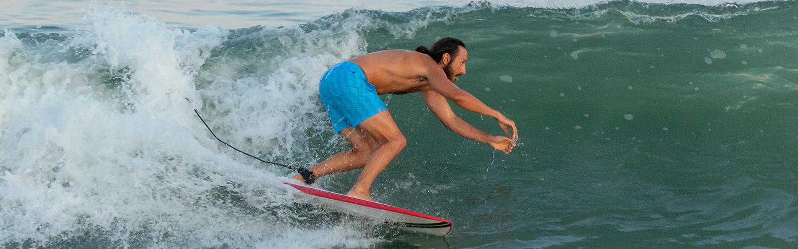 Man surfing wearing Stretch Swim 7" in Clearwater blue print