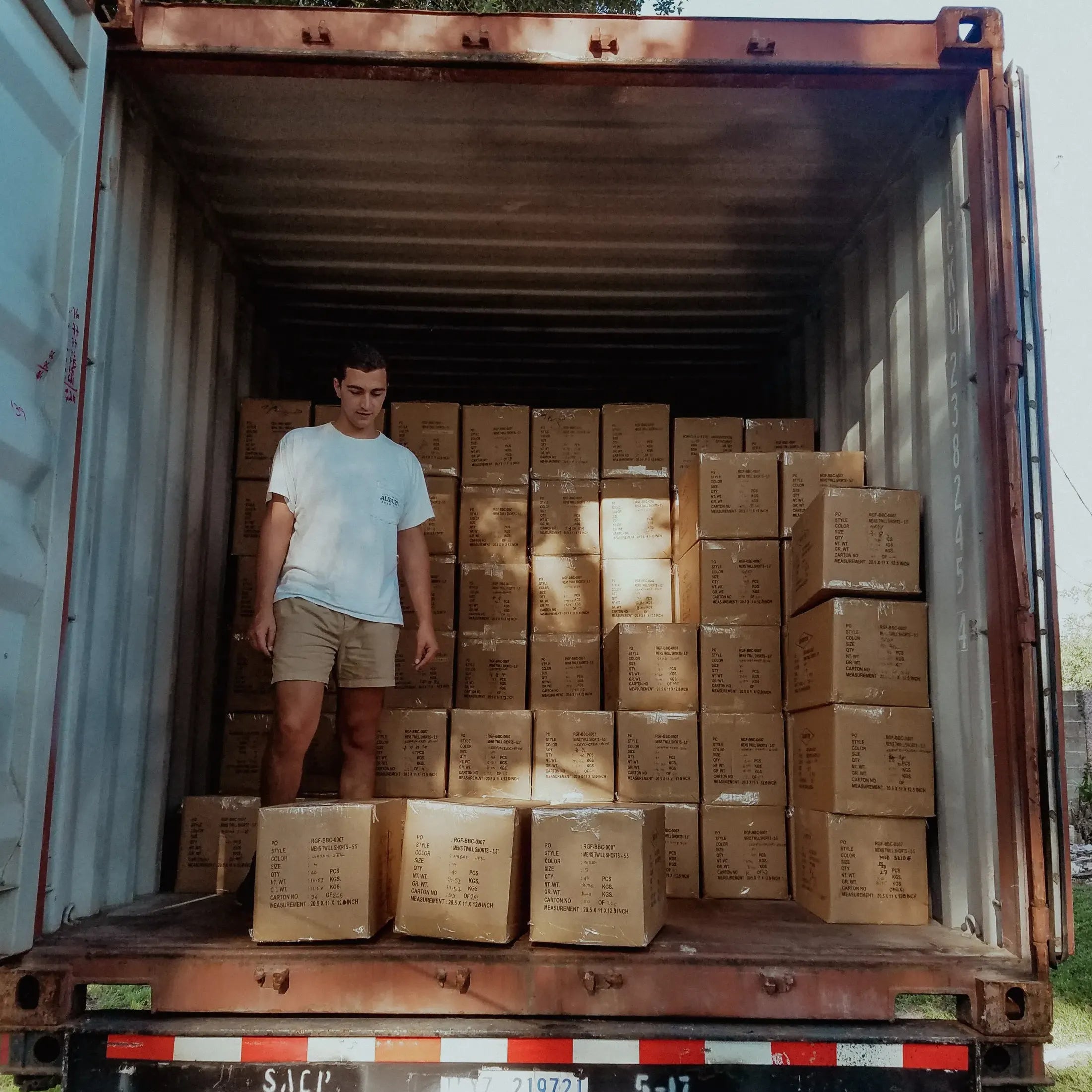 Robert Felder unloading boxes of clothes inside container truck