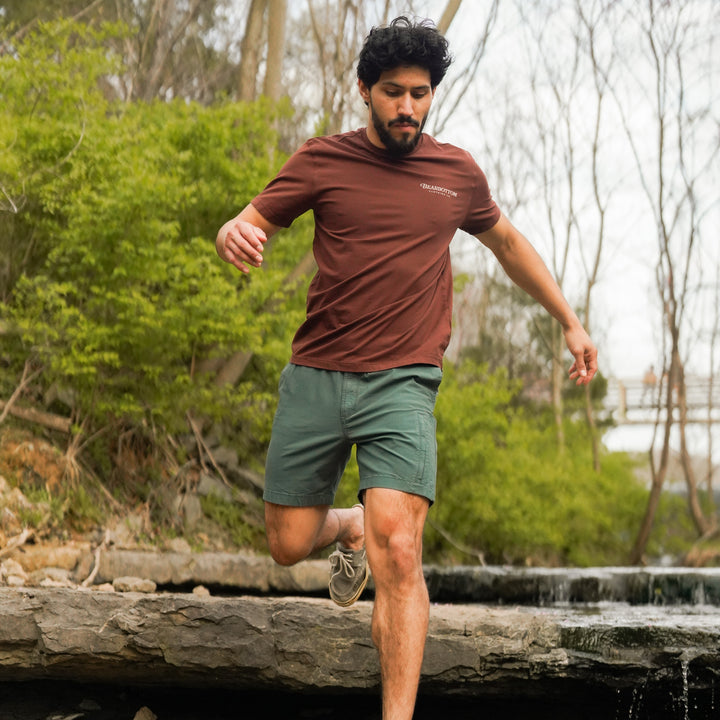 Man running outdoors wearing a Natural Dye Graphic Tee and Ridge Ripstop Short in Dark Sage