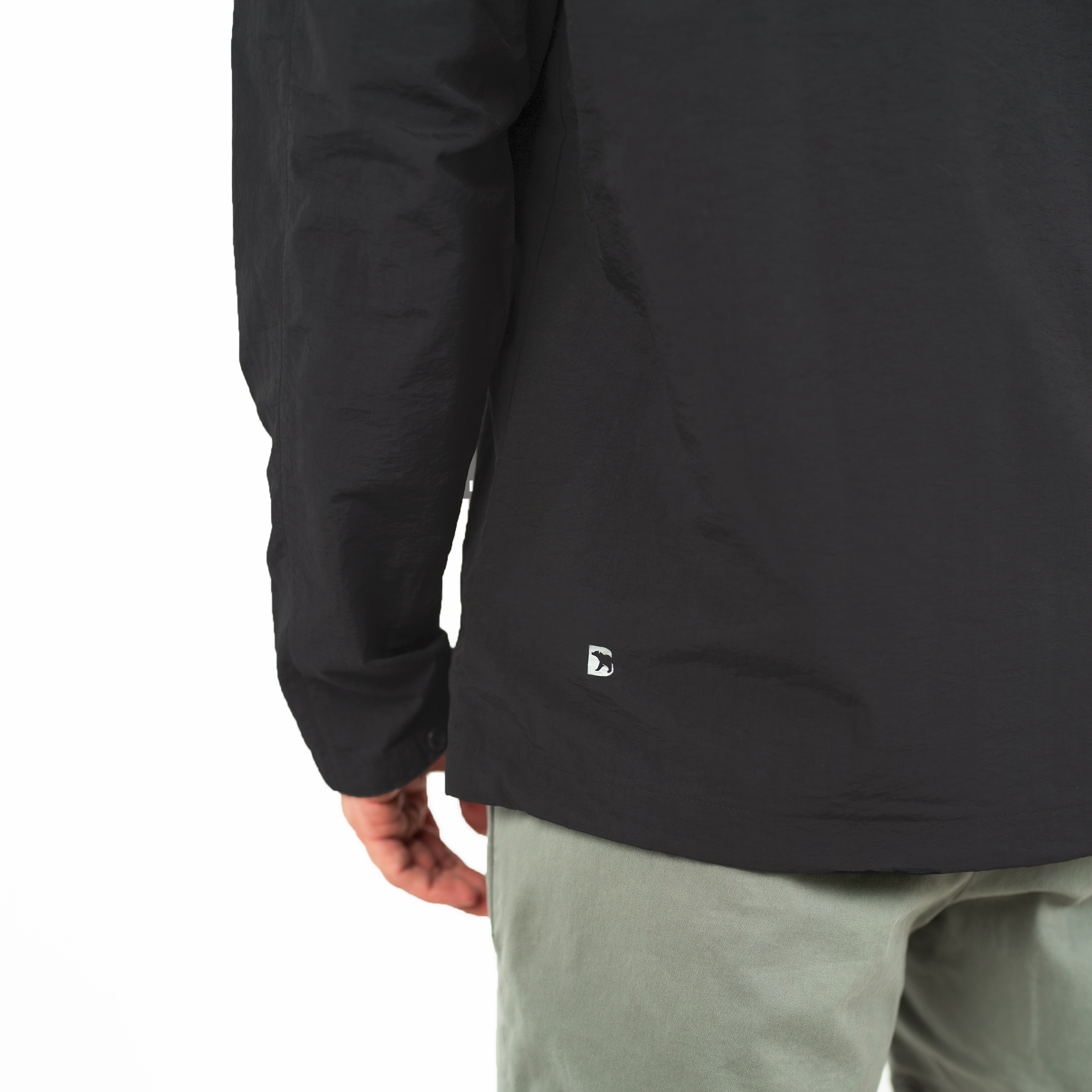 Windbreaker Jacket in Black close up of reflective Bearbottom B logo on back left side