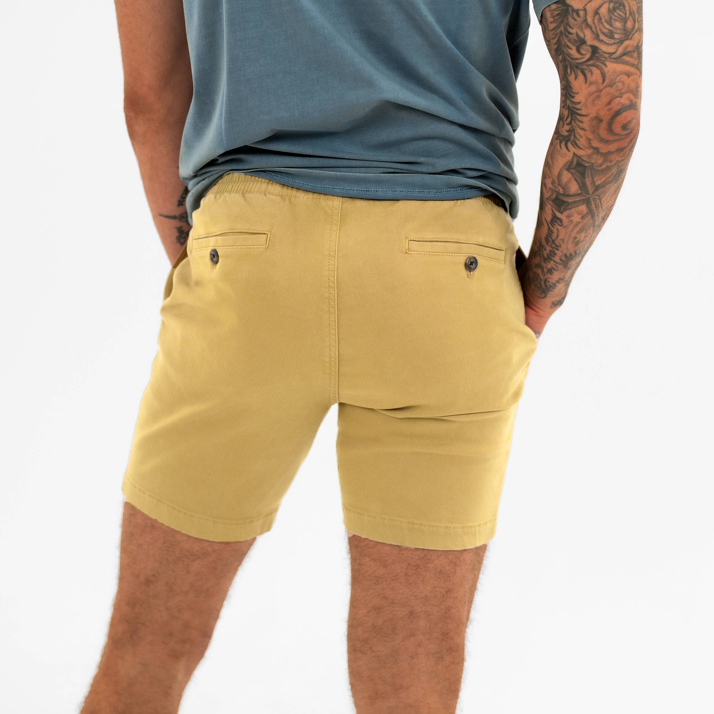 Alto Short 7" inseam in Khaki back on model with elastic waistband and two welt pocket with horn buttons