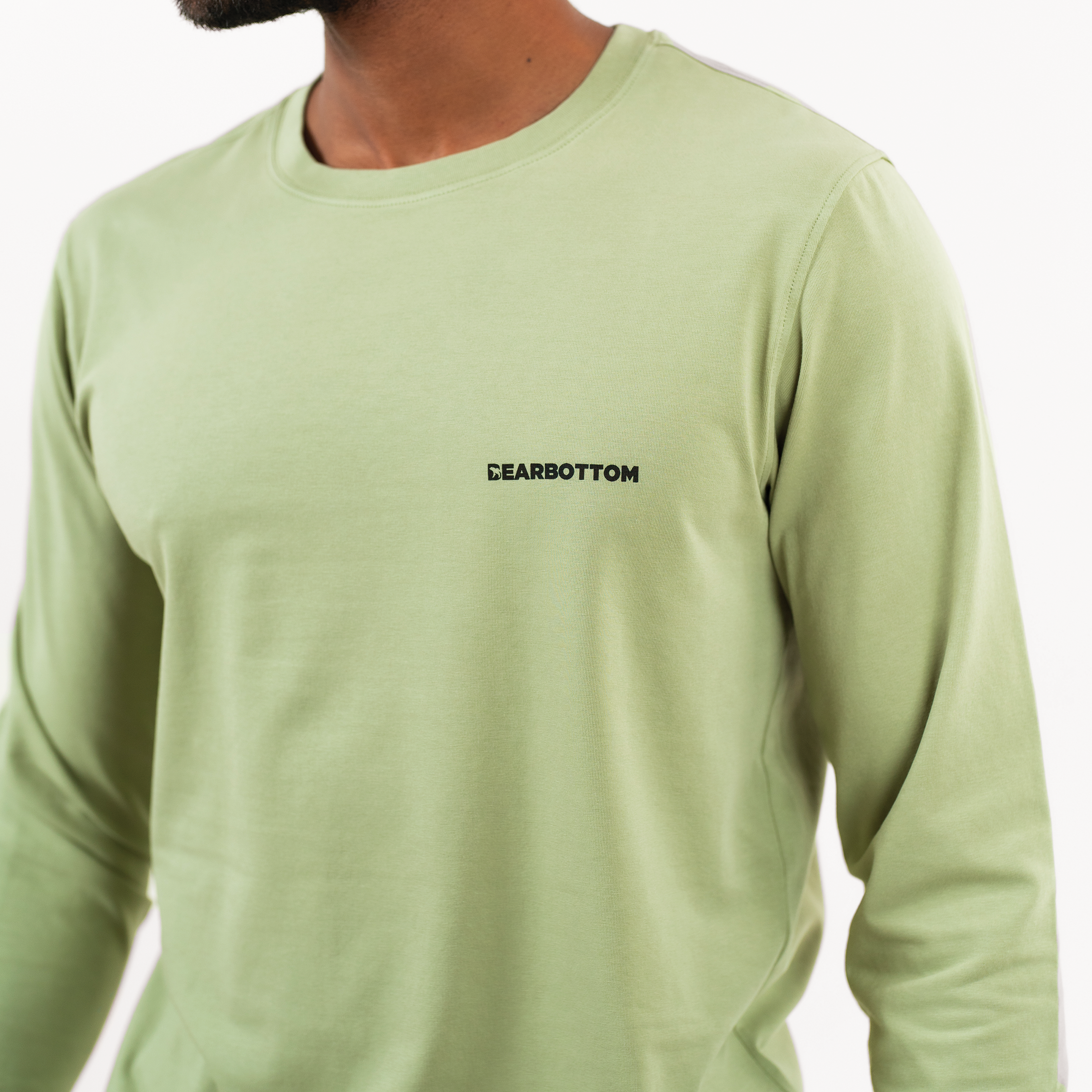 Natural Dye Logo Long Sleeve Tee in Sage green on model close up of Bearbottom logo on front left chest