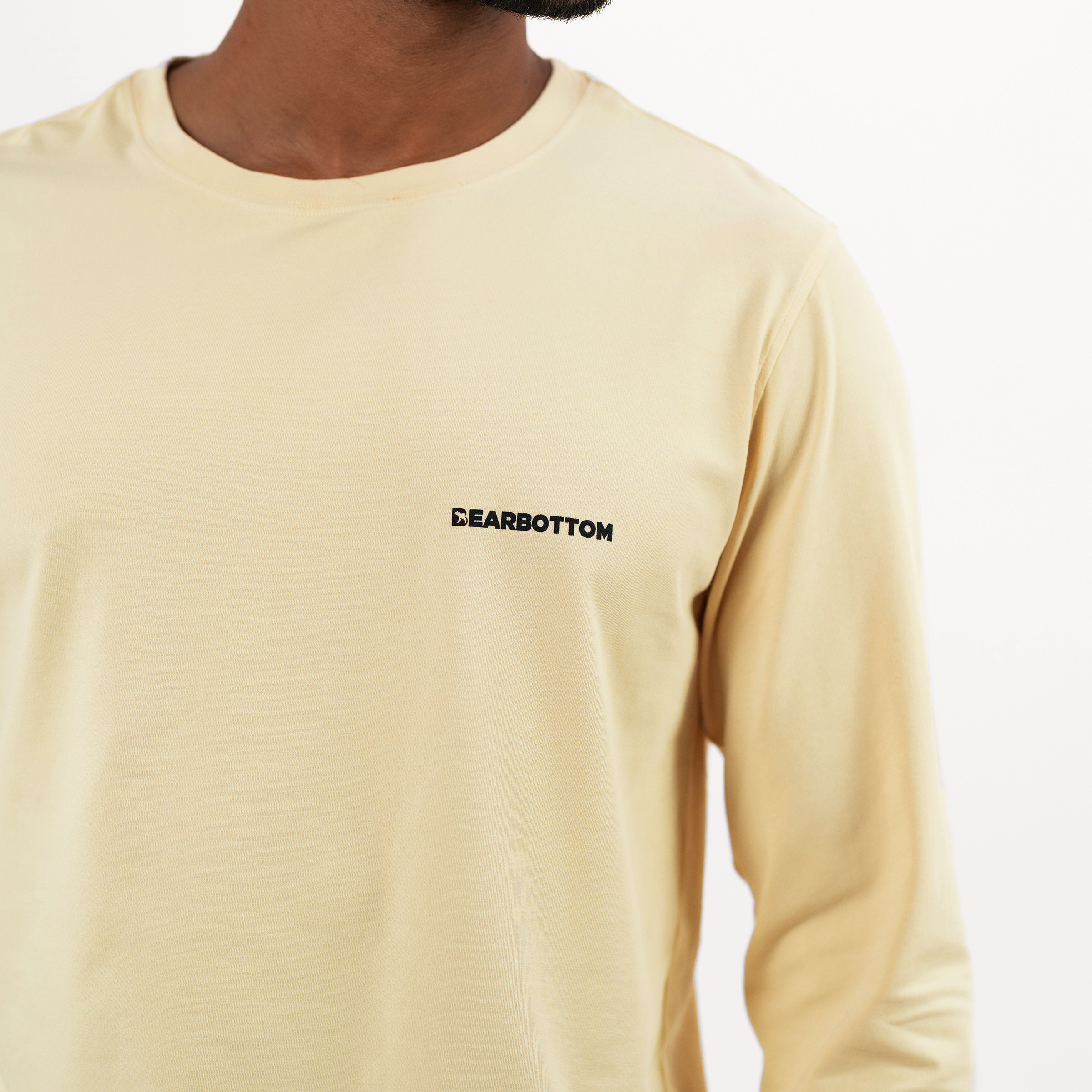 Natural Dye Logo Long Sleeve Tee in Sand yellow close up of Bearbottom logo on front left chest
