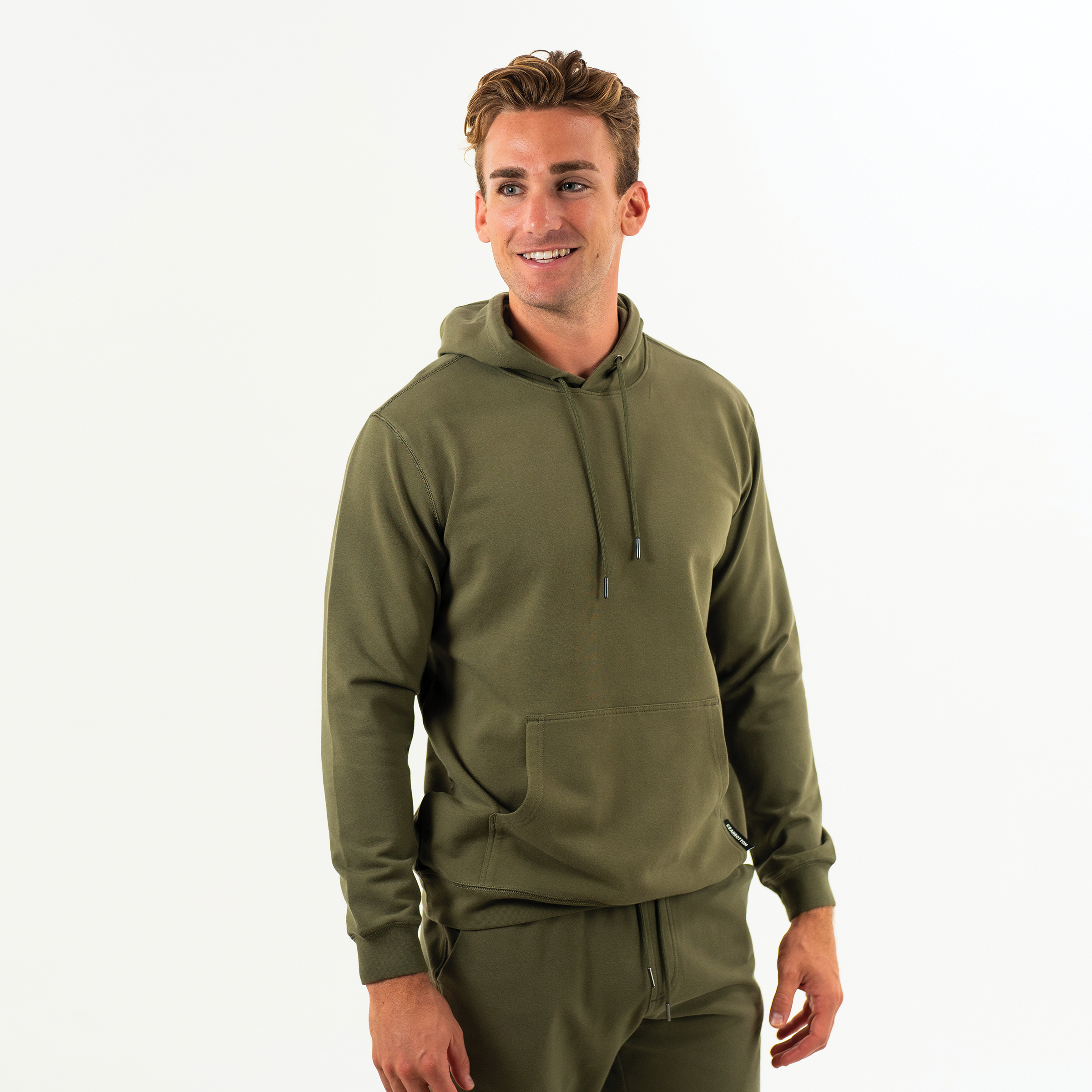 Loft Hoodie Dark Olive green on model with drawstrings with metal tips, kangaroo pocket, and ribbed wrists