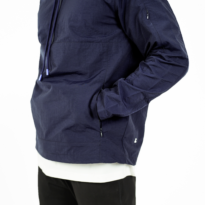 Windbreaker Jacket in Navy blue on model with hand in zippered kangaroo pocket